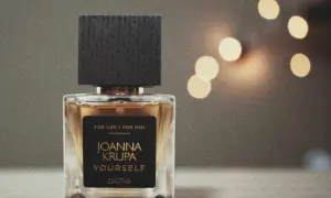Eleganckie perfumy Joanna Krupa Yourself, unisex, z nutami zapachowymi, w szklanym flakonie z czarną nakrętką.