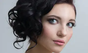 Delikatny makijaż na studniówkę podkreśla naturalne piękno młodej kobiety. Włosy ułożone w eleganckie fale dodają uroku.