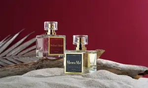 Dwa flakoniki perfum z feromonami, "Dubai Elixir" i "Mamma Mia!", na piasku i drewnie. Czy perfumy z feromonami działają?