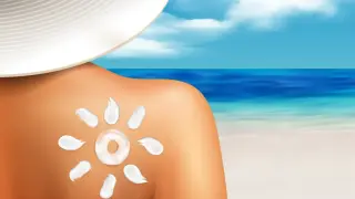Słońce na plecach, ochrona przed słońcem. Krem w kształcie słońca na skórze, plaża i morze w tle. Idealny sos po opalaniu.