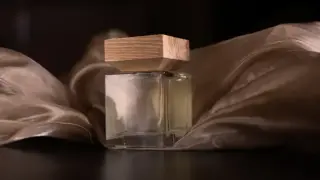 Elegancka buteleczka perfum z drewnianym korkiem, otulona złotym jedwabiem. Idealna inspiracja na prosty przepis na perfumy.