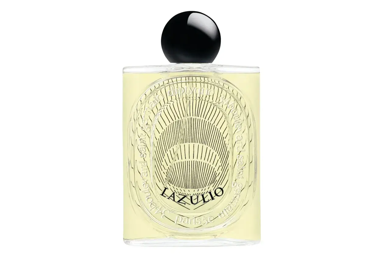 Elegancka butelka perfum Diptyque L'Eau Papier z czarną, błyszczącą nakrętką. Jasnożółty płyn i ozdobna etykieta z napisem "34 boulevard saint germain".