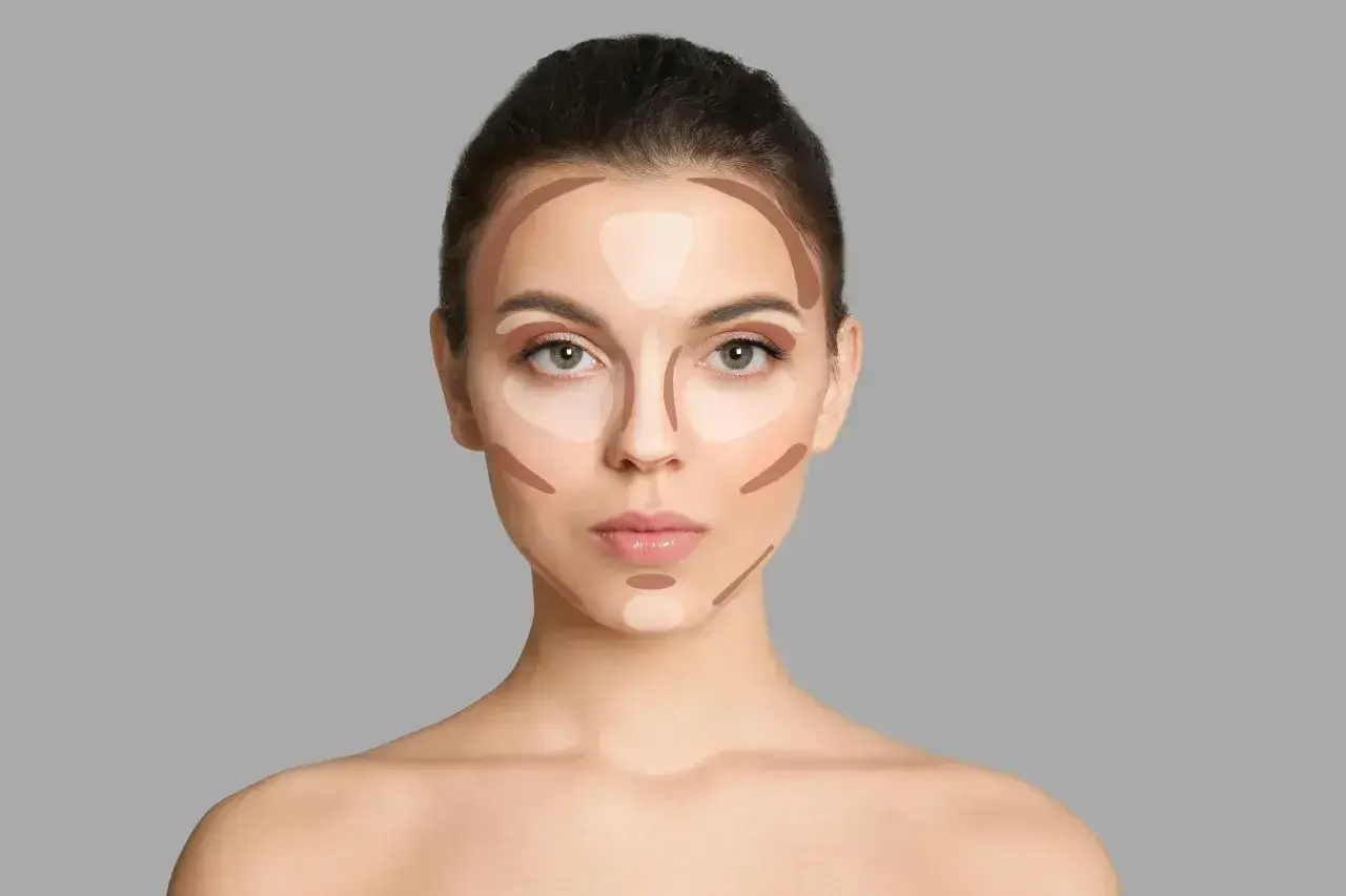 Modelka pokazuje, jak nakładać bronzer i rozświetlacz, tworząc efekt konturowania twarzy.