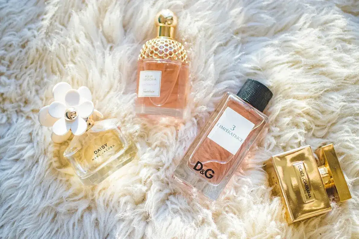 Jesienne zapachy: flakoniki perfum Daisy, Aqua Allegoria, L'Impératrice i Dolce&Gabbana na puszystym tle.