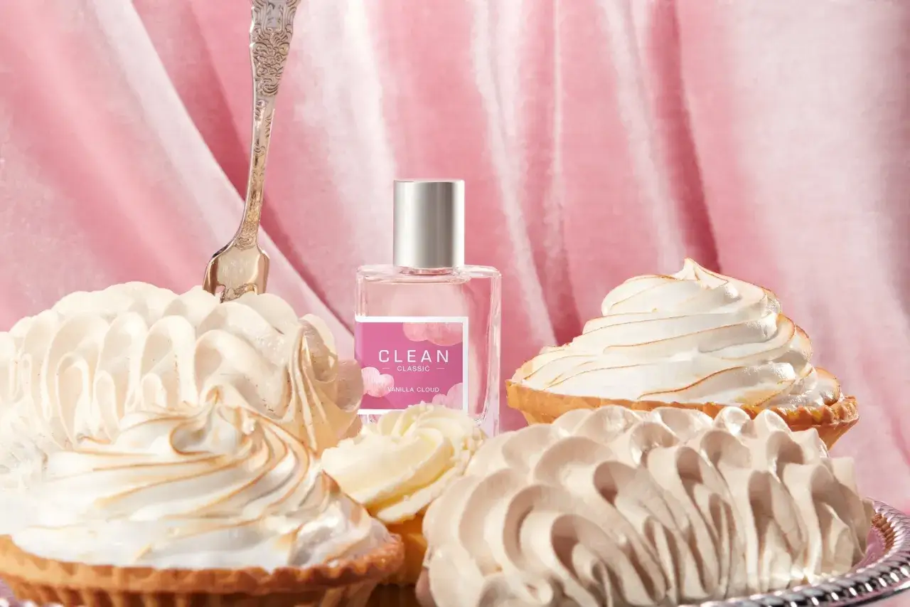 Słodkie tartaletki z bezą i kremem, obok buteleczka perfum CLEAN Vanilla Cloud. Zapach gourmand, który kusi jak deser.