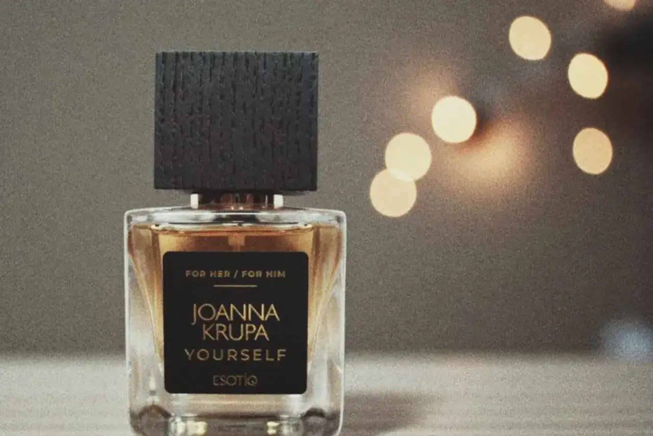 Eleganckie perfumy Joanna Krupa Yourself, z nutami zapachowymi dla Niej i dla Niego, w szklanym flakonie z czarną nakrętką.